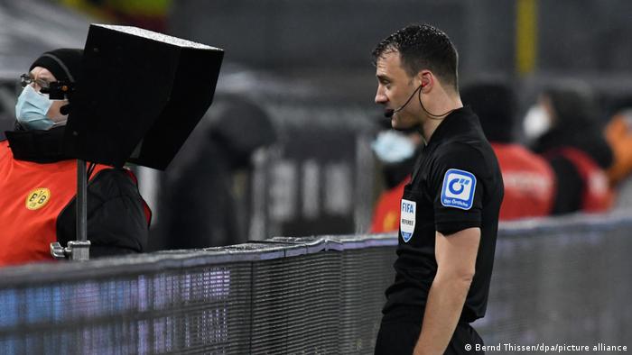 German referee Felix Zwayer looking at a monitor pitchside