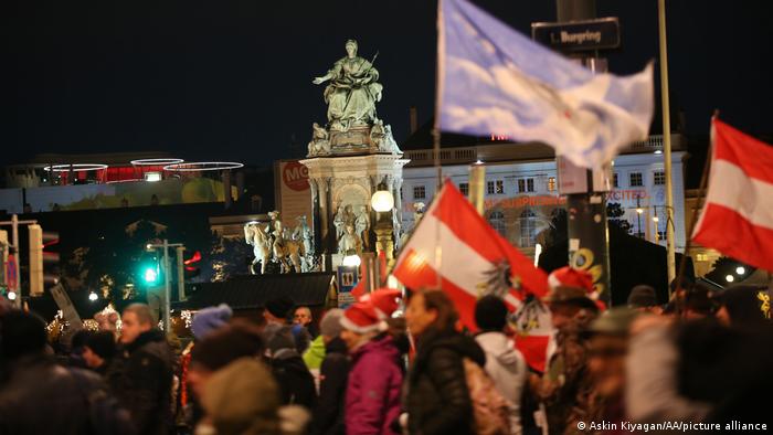 Protestors brandishing Austrian flags demonstrate against coronavirus measures in Vienna