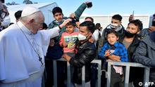 This handout photograph taken on December 5, 2021 and released by Vatican Media shows Pope Francis (L) meeting refugees at the Reception and Identification Centre in Mytilene on the island of Lesbos. (Photo by various sources / AFP) / RESTRICTED TO EDITORIAL USE - MANDATORY CREDIT AFP PHOTO / - / VATICAN MEDIA - NO MARKETING - NO ADVERTISING CAMPAIGNS - DISTRIBUTED AS A SERVICE TO CLIENTS