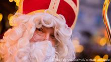 Stefan Dößereck, Nikolaus- und Weihnachtsmanndarsteller, trägt eine FFP2-Maske auf dem Weihnachtsmarkt Nikolausdorf auf dem Rudolfplatz. In diesem Jahr ist die Nachfrage nach professionellen Nikolaus-Darstellern weiterhin gering. Die Nikolaus-Zentrale in Münster verzeichnete einen Rückgang der Anfragen um 80 Prozent.