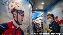 ZHANGJIAKOU, CHINA - DECEMBER 06: A cleaner and some passengers are seen inside the carriage of a train connecting Beijing to Taizicheng, Chongli, Zhangjiakou, decorated with winter sports and Olympics ornaments, on December 06, 2021 in China. The two places will be the main spots of the upcoming Beijing 2022 Winter Olympics. (Photo by Andrea Verdelli/Getty Images)
