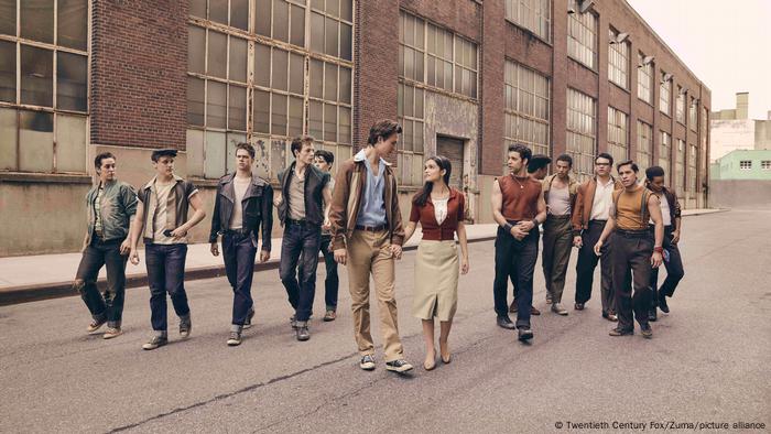 Straßenszene aus dem Remake West Side Story von Steven Spielberg, das ein verliebtes Pärchen und zwei Jugendgangs zeigt 
