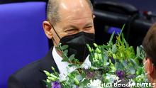 Designated German Chancellor Olaf Scholz receives flowers during a session of the German lower house of parliament Bundestag to elect a new chancellor, in Berlin, Germany, December 8, 2021. REUTERS/Fabrizio Bensch