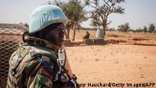 A Senegalese Blue Helmet peacekeeper stands next to United Nations (UN) armoured vehicle in the village of Ogossagou, Mopti Region on November 5, 2021. - Ogossagou village was attacked two times in two years, in 2019 and 2020, by unidentified armed men, that killed in total more than 200 civilians in a village of less that 800 people. (Photo by AMAURY HAUCHARD / AFP) (Photo by AMAURY HAUCHARD/AFP via Getty Images)
