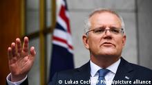 Australian Prime Minister Scott Morrison gestures during a press conference at Parliament House in Canberra, Australia, Monday, Nov. 22, 2021. The Australian government expects 200,000 vaccinated foreign students and skilled workers will return without quarantining when the country further relaxes border restrictions next week. (Lukas Coch/AAP Image via AP)