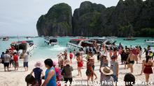 Tourists enjoy the beach on Maya Bay, Phi Phi Leh island in Krabi province, Thailand, Thursday, May 31, 2018. The popular tourist destination of Maya Bay in the Andaman Sea will close to tourists for four months from Friday to give its coral reefs and sea life a chance to recover from an onslaught that began nearly two decades ago. (AP Photo/Sakchai Lalit)