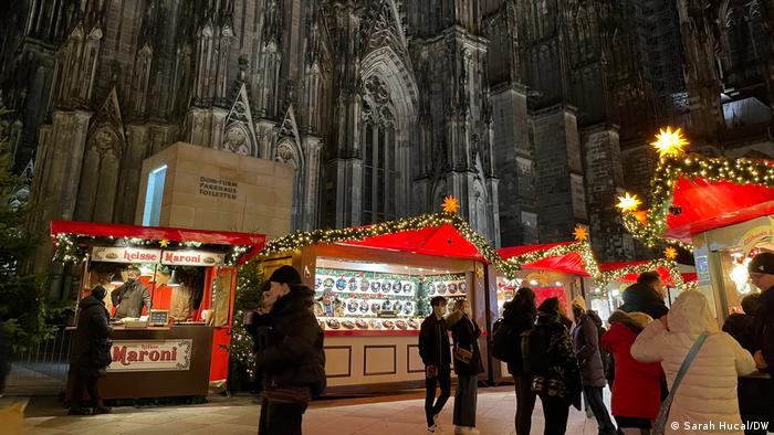 Booths of Christmas markets shine with lights at the foot of the Cologne cathedral