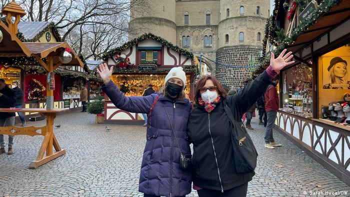 Zwei Frauen stehen auf dem Weihnachtsmarkt vor der Hahnentorburg in Köln