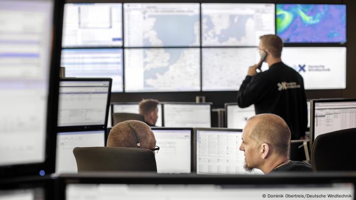 André Klatt (front right) and his colleagues sit in a control room in front of computers