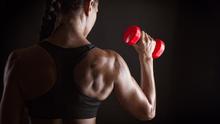 Fitness woman with barbells on dark background