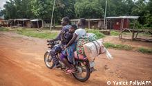 A family ride a motorbike as they flee the city of Save, on June 15, 2019, following days of unrest in the West African country of Benin. - Soldiers opened fire during clashes with protesters in Benin on June 14, as violence erupted after days of demonstrations following controversial parliamentary elections in April, witnesses said. (Photo by Yanick Folly / AFP)