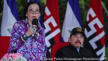 (FILES) Handout file photo taken on September 02, 2020 released by the Nicaraguan Presidency showing Nicaraguan President Daniel Ortega (R) listening to his wife and Vice President Rosario Murillo delivering a speech, during the 41st anniversary of the Nicaraguan Army, at the Plaza de la Revolucion, in Managua. - Murillo asked on December 6, 2021 for international sanctions against the government leaded by her husband Daniel Ortega to be lifted. Ortega was re-elected for a fourth consecutive term in an election in which most of his rivals were imprisoned. (Photo by Cesar PEREZ / Nicaraguan Presidency / AFP) / RESTRICTED TO EDITORIAL USE - MANDATORY CREDIT AFP PHOTO / NICARAGUAN PRESIDENCY / CESAR PEREZ - NO MARKETING - NO ADVERTISING CAMPAIGNS - DISTRIBUTED AS A SERVICE TO CLIENTS