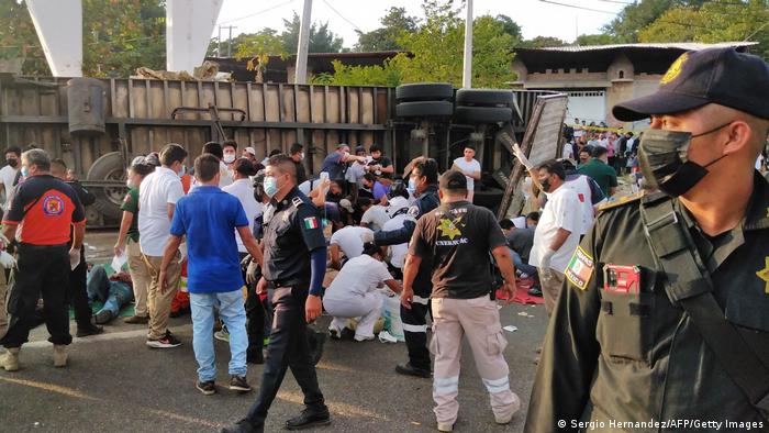 Police and rescue workers tend to victims of a crash in which at least 53 migrants died