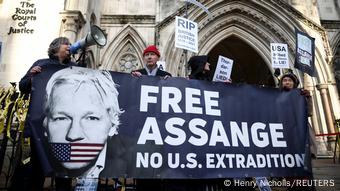 Manifestantes muestran su apoyo a Assange delante del Real Tribunal de Justicia con pancartas.