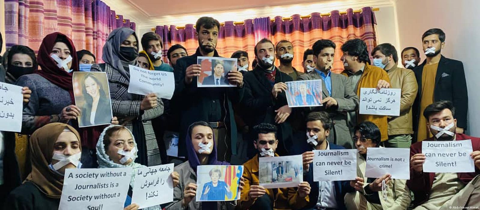 Journalists hold up signs protesting Afghanistan's ruling Taliban