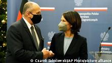 German Foreign Minister Annalena Baerbock ,right, and her Polish counterpart Zbigniew Rau bump fists after holding a joint press conference in Warsaw, Poland, Friday, Dec. 10, 2021. (AP Photo/Czarek Sokolowski)