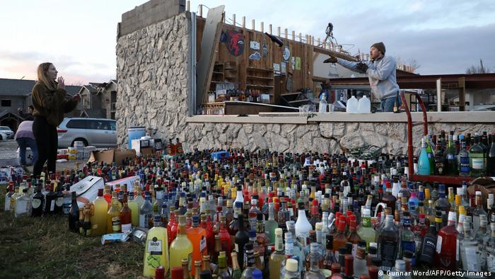 Botellas intactas ante una tienda destruida.