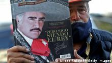 M12.12.2021
iguel del Toro, 65, shows a book on Mexican singer Vicente Fernandez's life outside the Country 2000 hospital in Guadalajara, Mexico, on December 12, 2021. - Fernandez, the most important representative of ranchera music in Mexico, died Sunday in Guadalajara at 81, after remaining in the hospital for almost five months due to a domestic accident, his family informed. (Photo by Ulises Ruiz / AFP) (Photo by ULISES RUIZ/AFP via Getty Images)