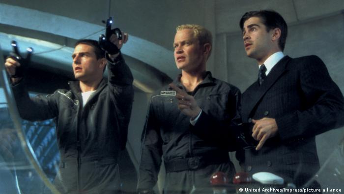 Film still Minority Report: Three men looking at something beyond the picture, with Tom Cruise manipulating a futuristic controller.