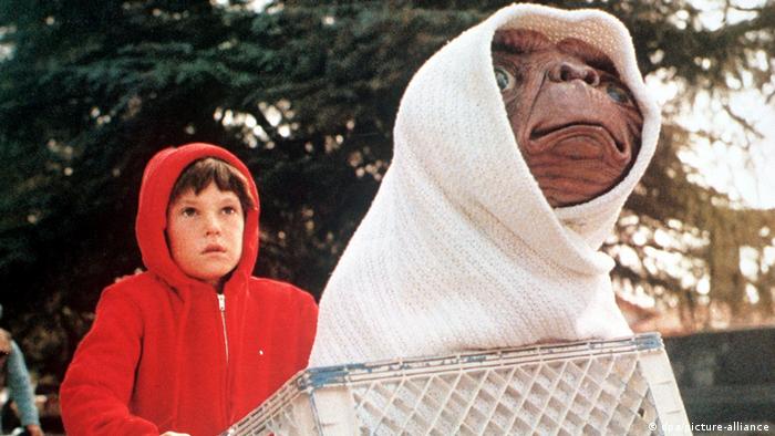 Filmstill aus E.T. - Der Außerirdische. Junge sitzt auf einem Fahrrad mit E.T. im Fahrradkorb.