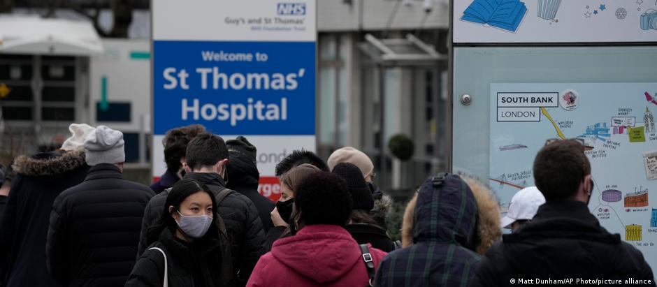 Em meio à rápida disseminação da ômicron no Reino Unido, pessoas fazem fila diante de hospital de Londres para receber dose de reforço