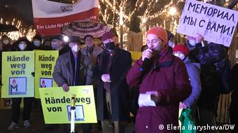 Мужчина с микрофоном и люди с плакатами в поддержку “Мемориала” на акции в Берлине