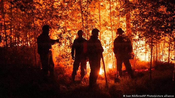 Firefighters work at the scene of forest fire near Yakutsk