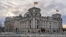 28.12.2020, Berlin, das Reichstagsgebäude von Baumeister Paul Wallot am Platz der Republik mit Beflaggung am Tag mit bewölktem Himmel. Der Reichstag ist der Sitz des Deutschen Bundestages mit Plenarbereich. Seitenansicht von der Spree-Seite.