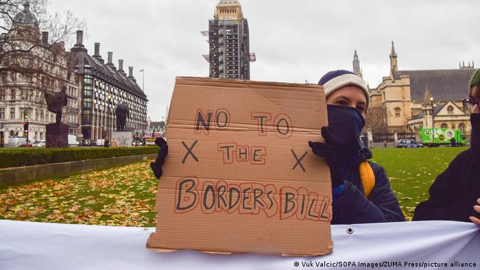 A protester in London holding up a sign that reads No to the Borders Bill