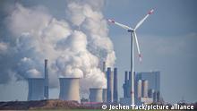 A wind energy turbine with a brown coal plant at Grevenbroich, Germany, in the background