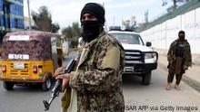 Taliban fighters stand guard along a roadside in Jalalabad on December 12, 2021. (Photo by WAKIL KOHSAR / AFP) (Photo by WAKIL KOHSAR/AFP via Getty Images)