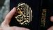 A person holds a copy of the Quran A person holds a copy of the Quran