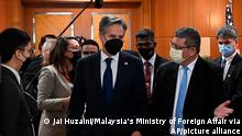 In this photo released by Malaysia's Ministry of Foreign Affair, U.S. Secretary of State Antony Blinken, center, is welcomed by Malaysian Foreign Minister Saifuddin Abdullah, right, at foreign ministry in Putrajaya, Malaysia, Wednesday, Dec. 15, 2021. (Jai Huzaini/Ministry of Foreign Affair via AP)
