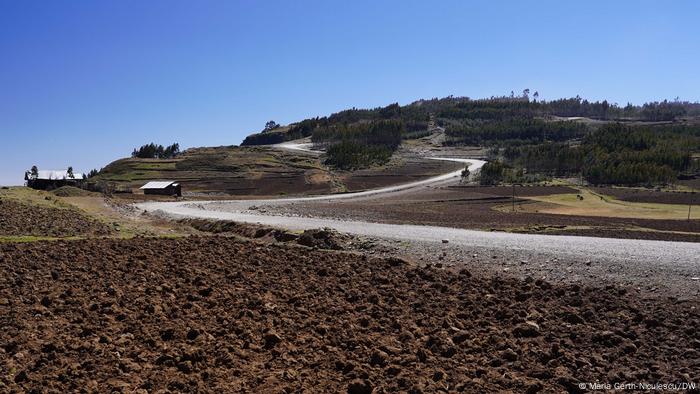 A gravel road leading to a hilltop 