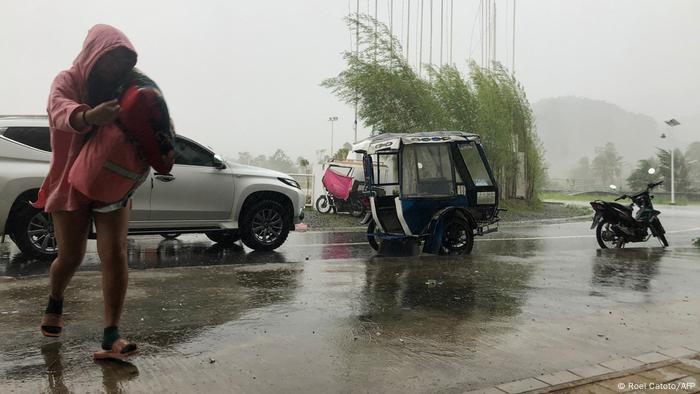 Person going to take shelter as wind whips road