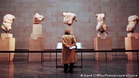  A woman looks at a section of the Parthenon Sculptures exhibit in the British Museum