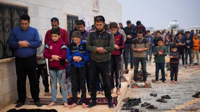 Men pray in one of the refugee camps in Idlib province, Syria.