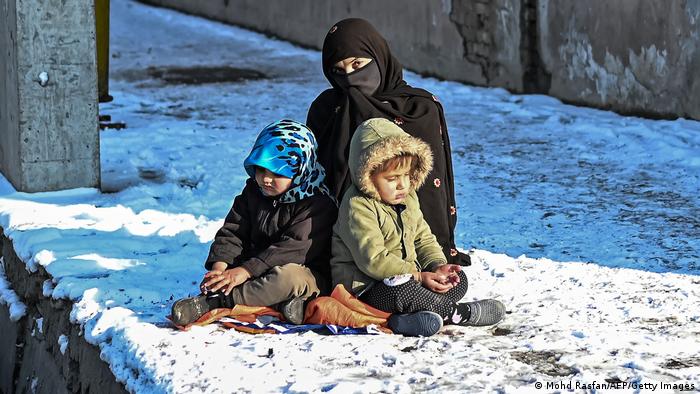 Seorang ibu membawa dua anaknya mengemis di kota Kabul di tengah musim dingin, (16/12/21)