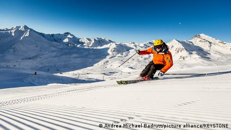 A lone skier on a high snow covered mountain range.