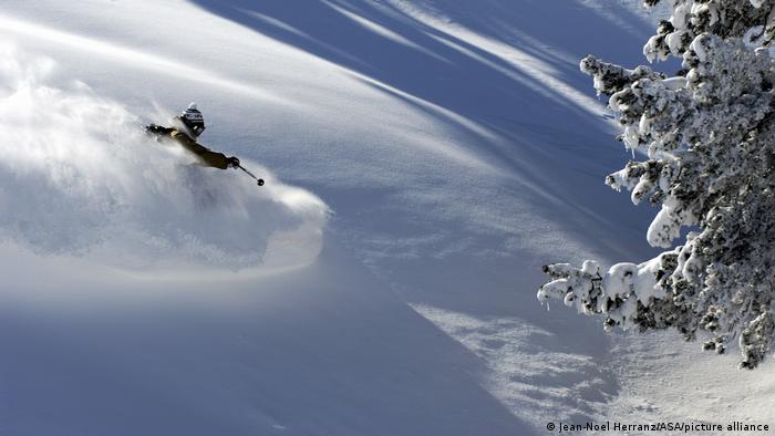 A skier going through deep snow on a slope in Baqueira-Beret, Spain 