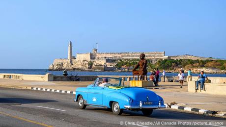 Blauer Oldtimer vor der Festungsanlage Castillo de los Tres Reyes del Morro in Havanna, Kuba