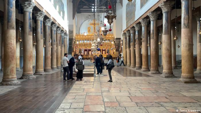 A handful of people in the nearly empty Church of the Nativity