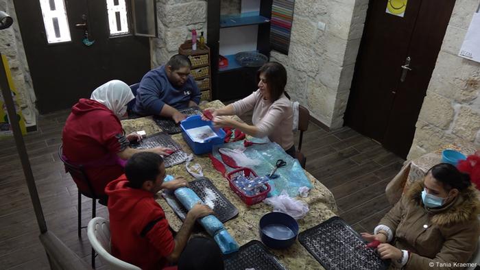 People sit around a table making crafts