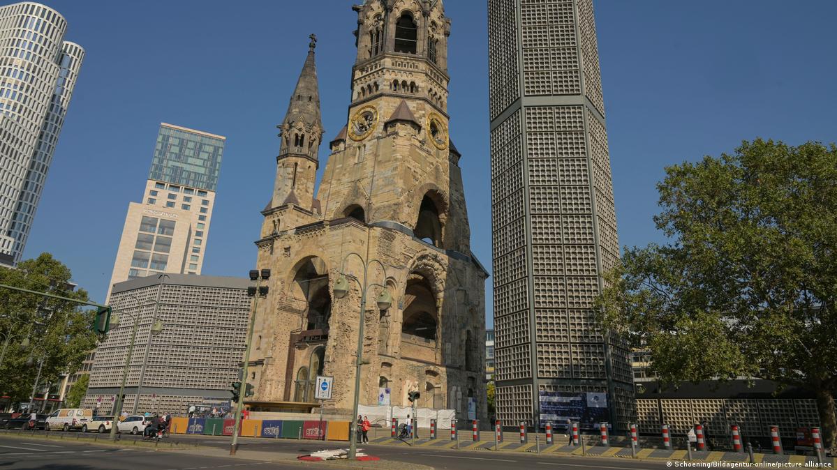 Foto mostra uma torre em estilo antigo, em parte destruída, ao lado de uma torre moderna.