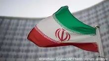 A national flag of Iran waves in front of the building of the International Atomic Energy Agency, IAEA, in Vienna, Austria, Friday, Dec. 17, 2021. (AP Photo/Michael Gruber)