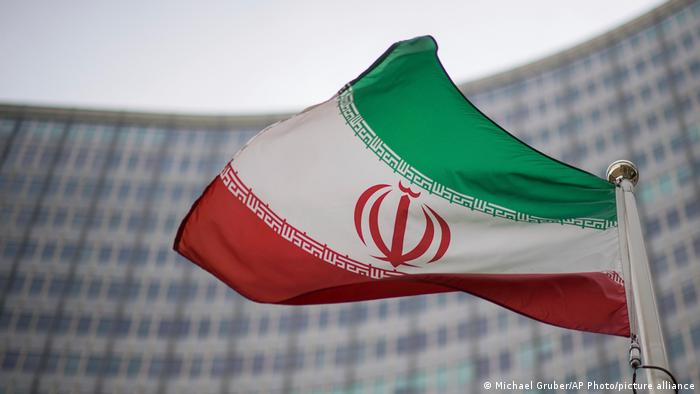 An Iranian waves in front of the International Atomic Energy Agency building in Vienna
