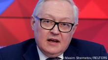 Russian Deputy Foreign Minister Sergei Ryabkov speaks against a red background