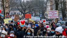 Teilnehmer der Querdenker-Demo gehen mit verschiedenen Schildern gegen Impfungen und gegen die Corona-Maßnahmen durch die Freiburger Innenstadt. Erwartet wurden laut Stadt 2500 Teilnehmer sowie 50 Gegendemonstranten.