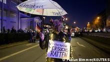 A person wearing a mask depicting a rat carries an umbrella and a placard reading We are not lab rats during a demonstration against coronavirus disease (COVID-19) measures, in Hamburg, Germany December 18, 2021. REUTERS/Fabian Bimmer
