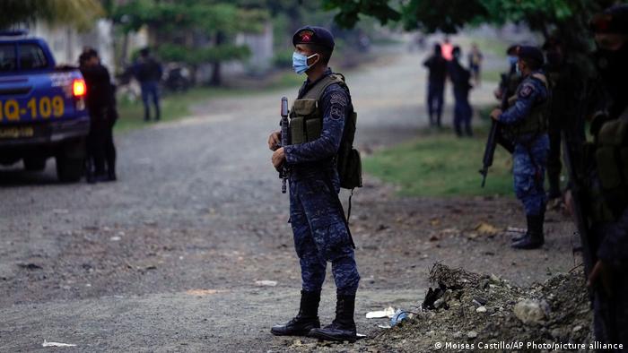 A Guatemalan soldier pictured with security personnel in the background
